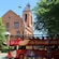A double decker tour bus with the words ‘City Sightseeing Kiel’ driving past a brick cathedral